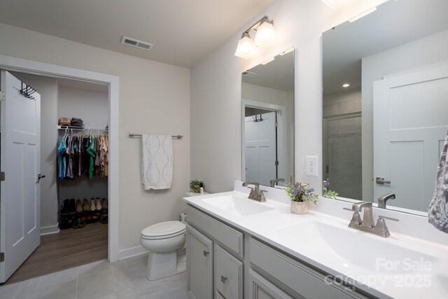 154 Stella Ln Unit A, Troutman, NC 28166 - bathroom featuring double vanity, tile patterned floors, a spacious closet, and a tile shower