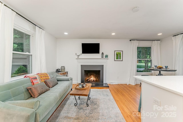 4014 Sulkirk Rd, Charlotte, NC 28210 - living room with light wood-style flooring, a warm lit fireplace, and recessed lighting