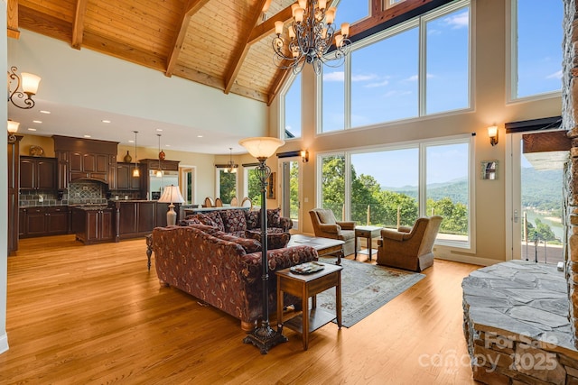 122 Eagles Crest Way, Lake Lure, NC 28746 - living area featuring high vaulted ceiling, a chandelier, light wood-style floors, a wooden ceiling with exposed beams, and a mountain view