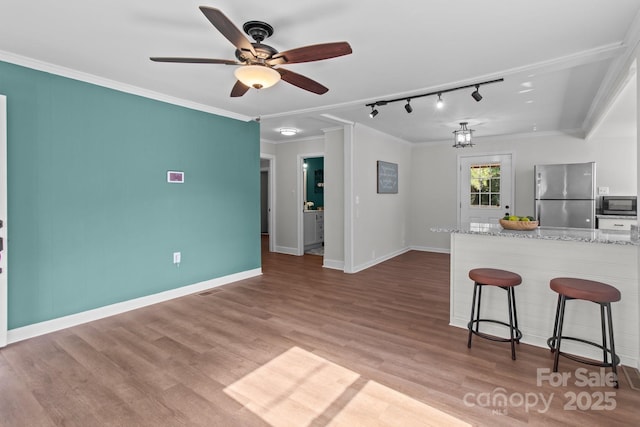 405 E 18th St, Kannapolis, NC 28083 - kitchen with freestanding refrigerator, black microwave, track lighting, a kitchen breakfast bar, and ornamental molding