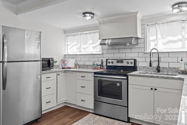 405 E 18th St, Kannapolis, NC 28083 - kitchen featuring stainless steel appliances, wall chimney range hood, dark wood-style flooring, crown molding, and tasteful backsplash