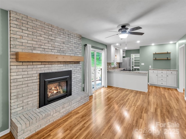 110 Stoney Brook Dr, Clyde, NC 28721 - unfurnished living room with light wood-style floors, a ceiling fan, a fireplace, recessed lighting, and baseboards