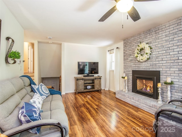110 Stoney Brook Dr, Clyde, NC 28721 - living area featuring a brick fireplace, wood finished floors, a ceiling fan, and baseboards