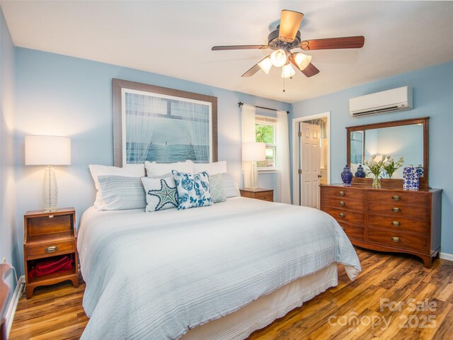 110 Stoney Brook Dr, Clyde, NC 28721 - bedroom with a wall unit AC, wood finished floors, a ceiling fan, and baseboards