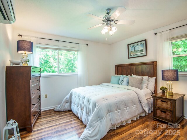 110 Stoney Brook Dr, Clyde, NC 28721 - bedroom featuring a wall mounted air conditioner, wood finished floors, baseboards, and a ceiling fan