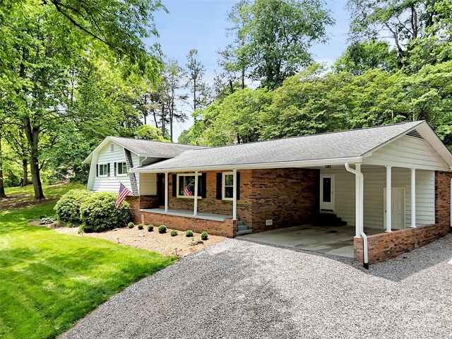 110 Stoney Brook Dr, Clyde, NC 28721 - tri-level home with driveway, an attached carport, a front yard, and brick siding