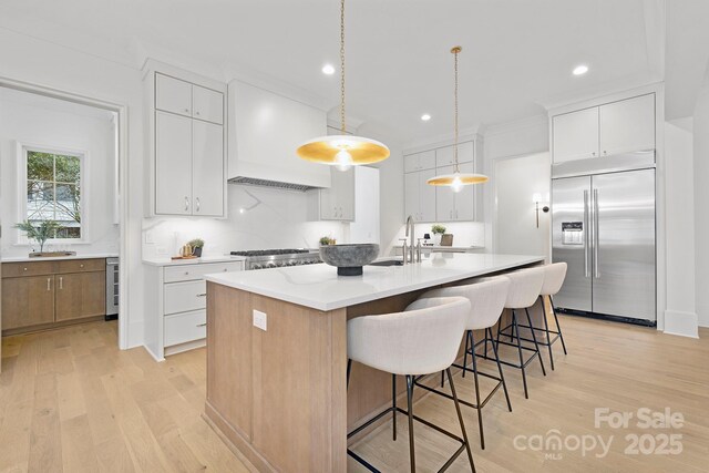 1321 Ferncliff Rd, Charlotte, NC 28211 - kitchen featuring stainless steel appliances, light wood finished floors, a breakfast bar, light countertops, and recessed lighting