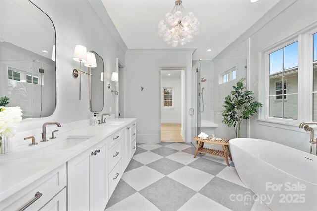 1321 Ferncliff Rd, Charlotte, NC 28211 - bathroom featuring a shower stall, double vanity, a freestanding bath, tile patterned floors, and a chandelier
