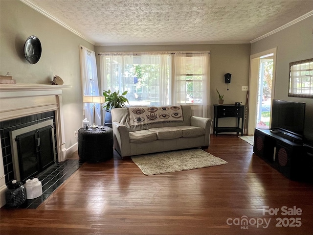 511 Westview St SW, Lenoir, NC 28645 - living area featuring wood finished floors, plenty of natural light, a tiled fireplace, ornamental molding, and a textured ceiling