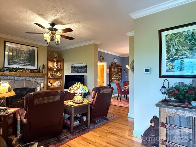 394 Hummingbird Ln, Elk Park, NC 28622 - living area with a fireplace, wood finished floors, ceiling fan, crown molding, and baseboards