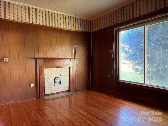 28 Central Ave, Granite Falls, NC 28630 - unfurnished living room featuring hardwood / wood-style floors, a fireplace, wooden walls, and ornamental molding