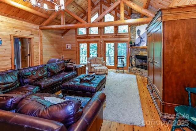 184 Sunlight Path, Lake Lure, NC 28746 - living room with a wooden ceiling with exposed beams, wooden walls, hardwood / wood-style flooring, high vaulted ceiling, and a stone fireplace