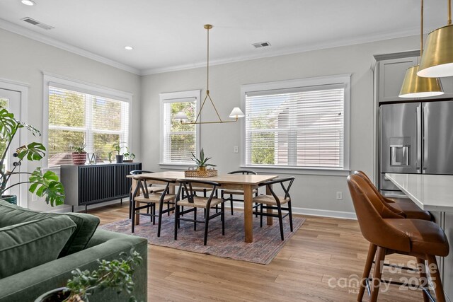 11329 Fullerton Place Dr NW, Huntersville, NC 28078 - dining space with healthy amount of natural light, light wood-style floors, crown molding, recessed lighting, and baseboards