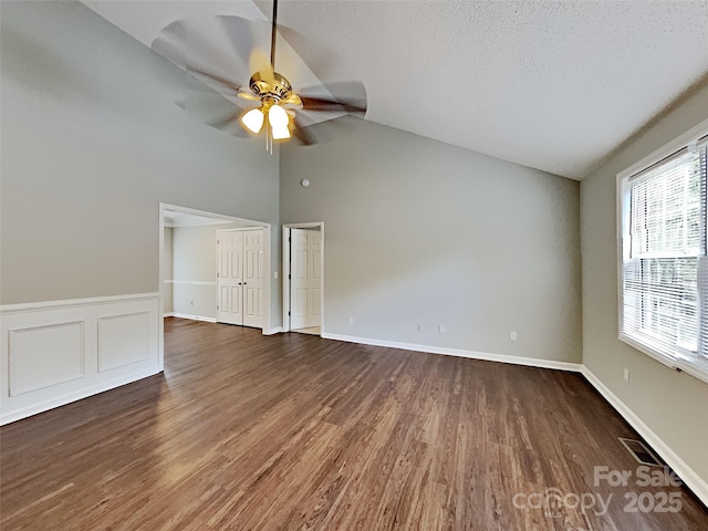 120 Todd Dr NW, Concord, NC 28025 - empty room featuring healthy amount of natural light, ceiling fan, dark wood finished floors, high vaulted ceiling, and baseboards