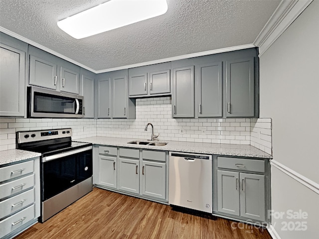 120 Todd Dr NW, Concord, NC 28025 - kitchen with appliances with stainless steel finishes, a sink, gray cabinets, a textured ceiling, and wood finished floors