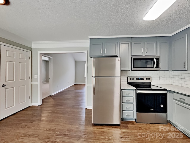 120 Todd Dr NW, Concord, NC 28025 - kitchen with appliances with stainless steel finishes, gray cabinetry, a textured ceiling, tasteful backsplash, and wood finished floors