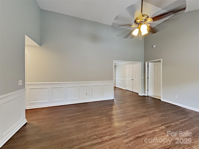 120 Todd Dr NW, Concord, NC 28025 - spare room featuring a high ceiling, ceiling fan, dark wood finished floors, and wainscoting