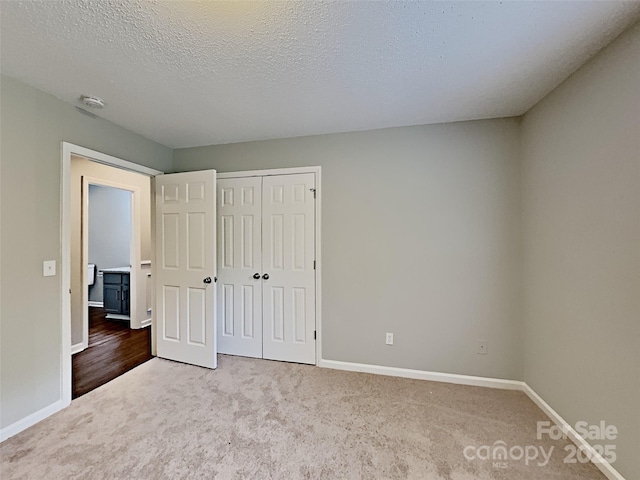 120 Todd Dr NW, Concord, NC 28025 - unfurnished bedroom featuring carpet floors, baseboards, a closet, and a textured ceiling