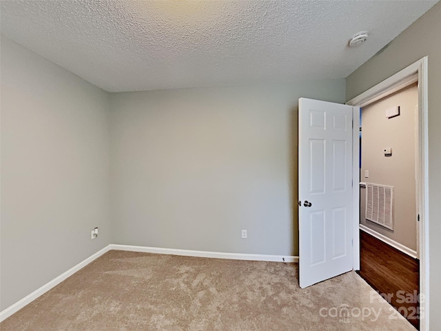 120 Todd Dr NW, Concord, NC 28025 - empty room featuring light colored carpet, baseboards, a textured ceiling, and a smoke detector