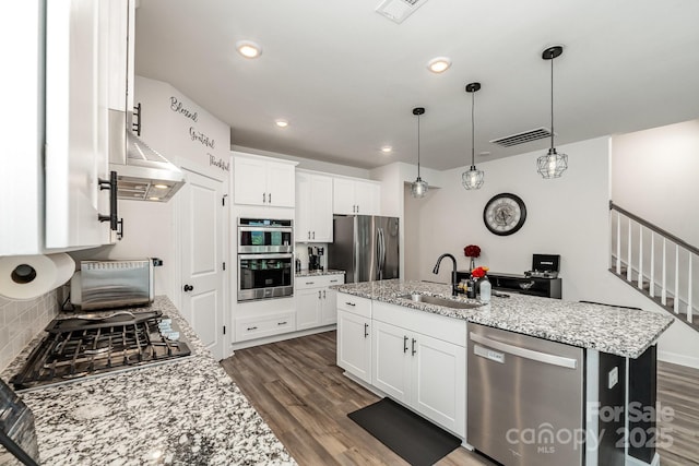 9274 Dunwich Dr, Gastonia, NC 28056 - kitchen with stainless steel appliances, a sink, a kitchen island with sink, dark wood-style flooring, and light stone countertops