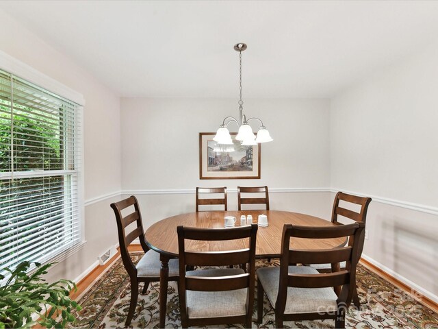 13617 Lake Bluff Dr, Matthews, NC 28105 - dining space featuring wood finished floors, a chandelier, and baseboards