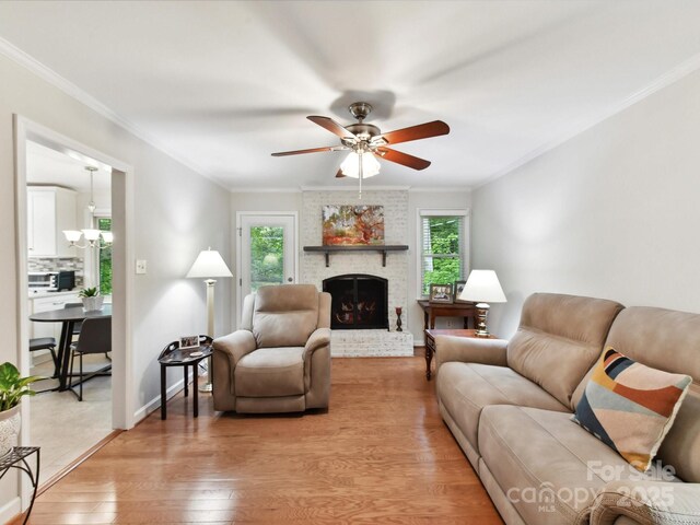 13617 Lake Bluff Dr, Matthews, NC 28105 - living area with light wood-style flooring, crown molding, ceiling fan, a fireplace, and baseboards