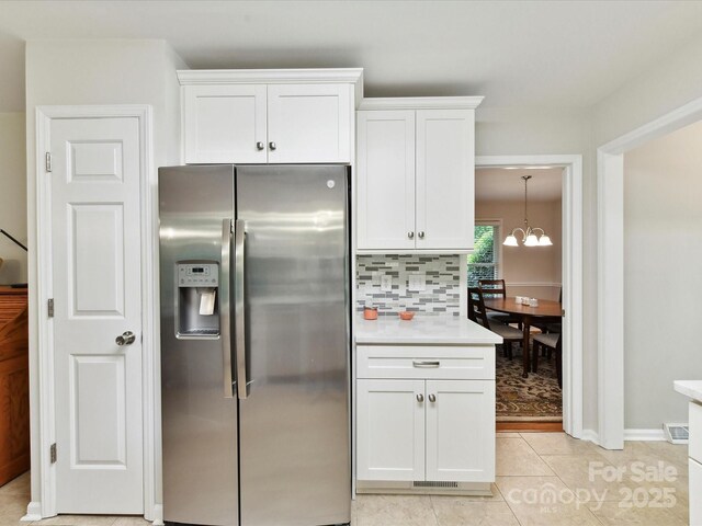 13617 Lake Bluff Dr, Matthews, NC 28105 - kitchen with stainless steel fridge with ice dispenser, white cabinetry, a chandelier, light countertops, and decorative backsplash