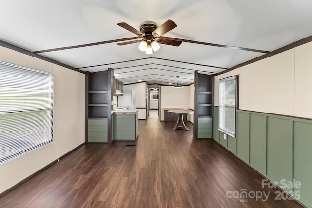 1712 NC-126 Hwy, Morganton, NC 28655 - unfurnished living room with plenty of natural light, ceiling fan, dark wood-type flooring, vaulted ceiling, and a wainscoted wall