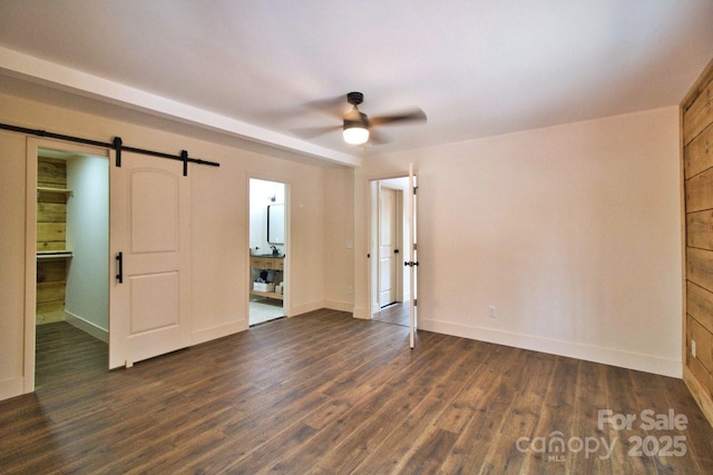 317 Knightsbridge Cir, Union Mills, NC 28167 - unfurnished bedroom featuring a barn door, dark wood-type flooring, and baseboards