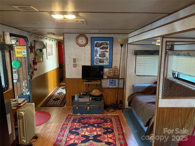 160/162 Arrowood Trl Unit F28/F29, Mount Gilead, NC 27306 - bedroom with wood finished floors, radiator, wooden walls, and wainscoting