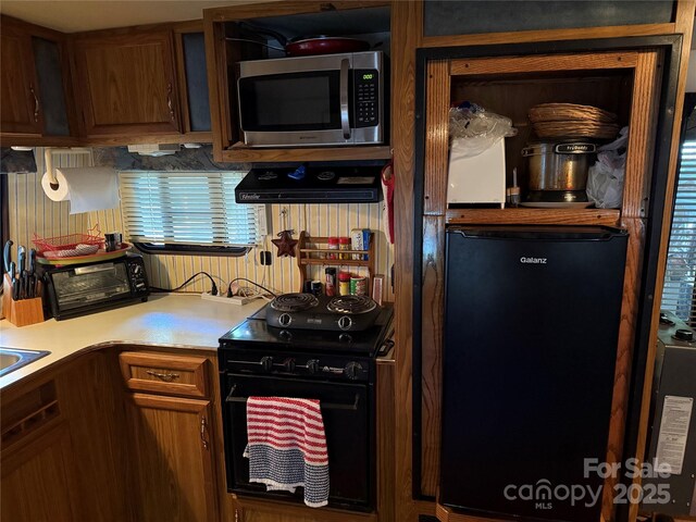160/162 Arrowood Trl Unit F28/F29, Mount Gilead, NC 27306 - kitchen featuring stainless steel microwave, black range with electric cooktop, refrigerator, light countertops, and range hood