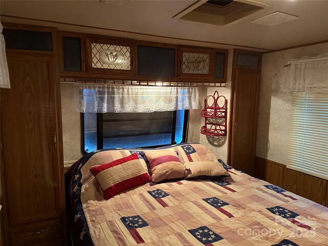 160/162 Arrowood Trl Unit F28/F29, Mount Gilead, NC 27306 - bedroom with a wainscoted wall and wooden walls
