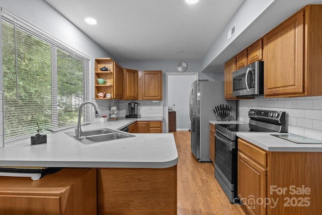 7212 Morsey Ct, Charlotte, NC 28269 - kitchen with stainless steel appliances, a sink, light wood-style flooring, a peninsula, and open shelves