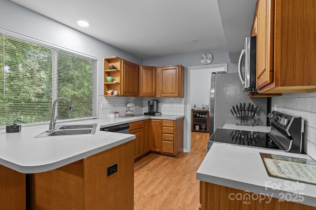 7212 Morsey Ct, Charlotte, NC 28269 - kitchen with appliances with stainless steel finishes, a sink, brown cabinets, a peninsula, and light wood-type flooring