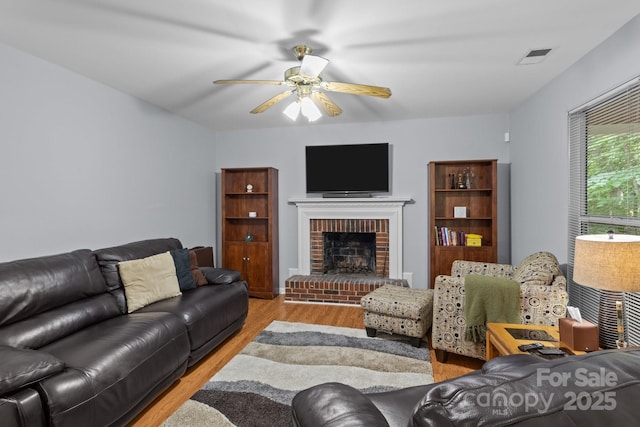 7212 Morsey Ct, Charlotte, NC 28269 - living area with wood finished floors, a ceiling fan, and a brick fireplace