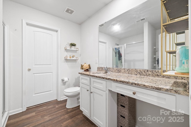 2011 Valdosta Way, Charlotte, NC 28215 - bathroom featuring wood finished floors, toilet, vanity, and a stall shower