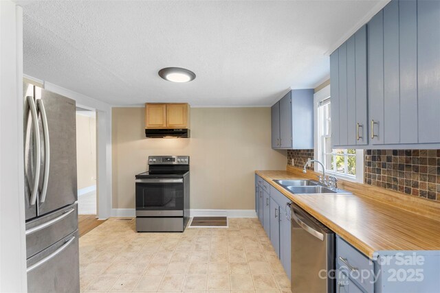 202 Glenn Ave, Kannapolis, NC 28081 - kitchen featuring stainless steel appliances, under cabinet range hood, backsplash, light countertops, and a textured ceiling