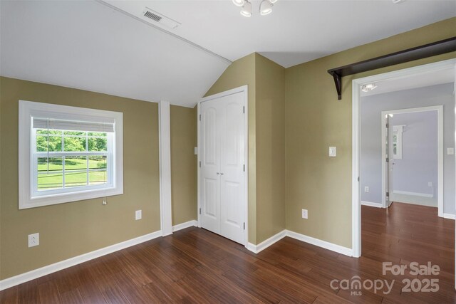202 Glenn Ave, Kannapolis, NC 28081 - unfurnished bedroom featuring dark wood-style floors, vaulted ceiling, and a closet