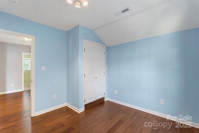 202 Glenn Ave, Kannapolis, NC 28081 - unfurnished bedroom featuring dark wood-style flooring, lofted ceiling, and a closet
