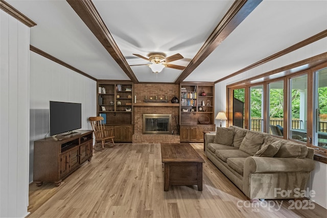 2917 Rustic Ln, Charlotte, NC 28210 - living area featuring light wood-style floors, beam ceiling, a ceiling fan, a fireplace, and crown molding