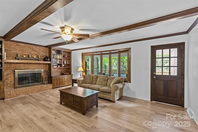 2917 Rustic Ln, Charlotte, NC 28210 - living area featuring light wood finished floors, a brick fireplace, a ceiling fan, beamed ceiling, and ornamental molding