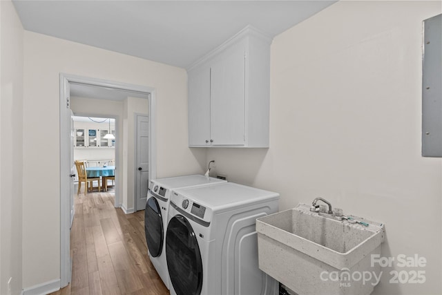 2917 Rustic Ln, Charlotte, NC 28210 - laundry room with cabinet space, washer and clothes dryer, and light wood-style flooring