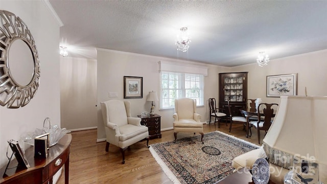 1695 Arden Dr, Lincolnton, NC 28092 - living area with a chandelier, crown molding, light wood-style flooring, and a textured ceiling