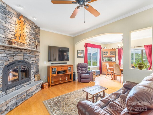 80 Feather Ln, Waynesville, NC 28786 - living area featuring arched walkways, wood finished floors, ornamental molding, a ceiling fan, and a fireplace