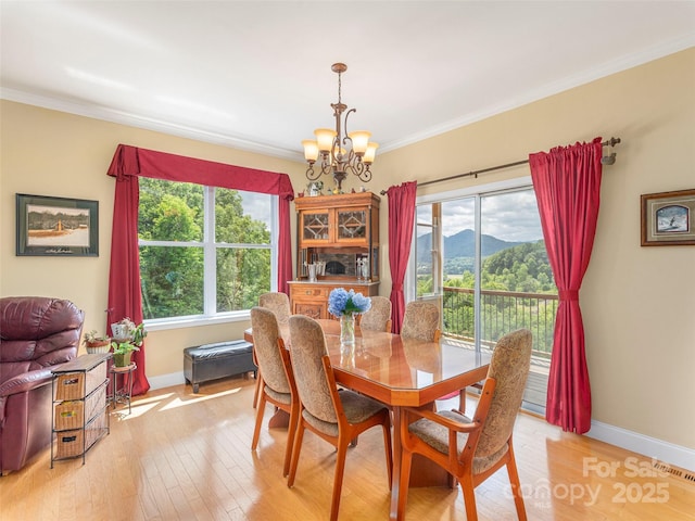 80 Feather Ln, Waynesville, NC 28786 - dining space featuring a chandelier, ornamental molding, light wood finished floors, and a mountain view