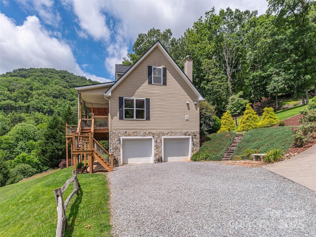 80 Feather Ln, Waynesville, NC 28786 - view of front of house with stairway, gravel driveway, an attached garage, stone siding, and a front lawn