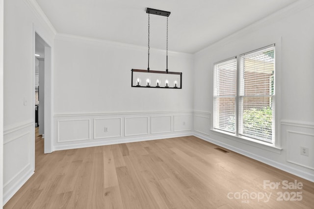 15400 Groveland St, Huntersville, NC 28078 - unfurnished dining area with crown molding, healthy amount of natural light, light wood-style floors, wainscoting, and a decorative wall