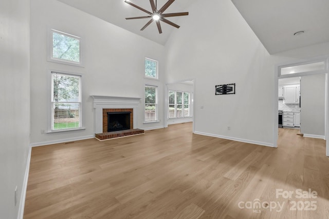 15400 Groveland St, Huntersville, NC 28078 - unfurnished living room with ceiling fan, high vaulted ceiling, a fireplace, and light wood-style flooring