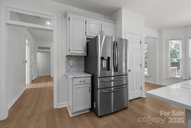 15400 Groveland St, Huntersville, NC 28078 - kitchen featuring stainless steel refrigerator with ice dispenser, light wood finished floors, light countertops, tasteful backsplash, and white cabinetry