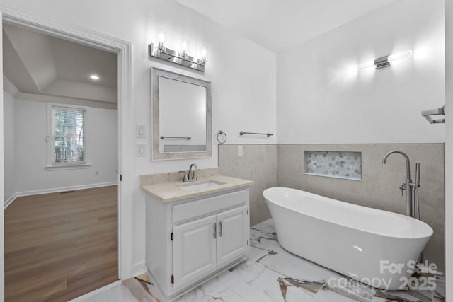 15400 Groveland St, Huntersville, NC 28078 - full bathroom with vanity, a freestanding tub, tile walls, wainscoting, and a raised ceiling